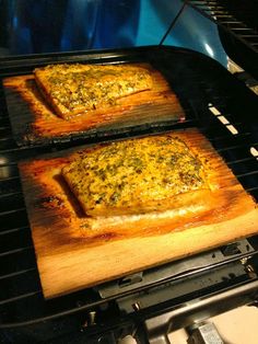 two square pizzas cooking on an outdoor grill