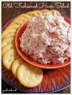 a plate with crackers on it and a bowl of crab salad in the middle