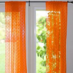 an orange curtain is hanging in front of a window