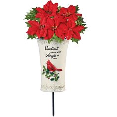 a red poinsettia in a white ceramic vase