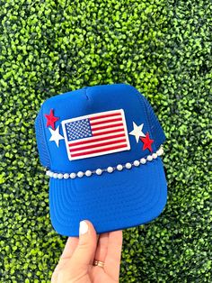 The perfect accessory for the summer and all the patriotic events!! Hat comes with flag  patch and star patches. Also features a hat chain.  Choose your color hat to fit your style. We have several color options to choose from. Hat Details: 100% Polyester foam front, mesh back Structured, five-panel, mid-profile 3 ½" crown Pre-curved visor with braid detailing Adjustable double snapback closure Summer Patriotic Trucker Hat With Curved Brim, Patriotic Summer Snapback Trucker Hat, Adjustable Blue Trucker Hat For 4th Of July, Patriotic Trucker Hat For 4th Of July, Patriotic Blue Trucker Hat For 4th Of July, Patriotic Snapback Hat For Veterans Day, Patriotic Adjustable Trucker Hat For 4th Of July, Patriotic Trucker Hat For 4th Of July Snapback, Patriotic Adjustable Hat For Independence Day