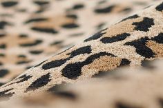 an animal print area rug with black and white spots on it's edges, close up