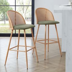 two wicker bar stools in front of a window