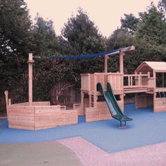 a wooden play area with a slide and climbing frame