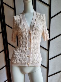 How cute! Love this little cardi, great for a vintage look. Perfect and in pretty good condition aside from general pilling/wear to the material. Luckily with the texture, this blends into the garment and isn't too obvious.  Size is labeled with measurements to fit Bust 100cm, Waist 80cm, Hips 105cm so XL but fits well on the mannequin which is a XSmall so would work for many sizes. Vintage V-neck Knit Sweater, Vintage V-neck Knit Cardigan, Retro Cotton Beige Sweater, Retro Beige Cotton Sweater, Fitted Cream Cardigan With Textured Knit, Fitted Cream Textured Knit Cardigan, Fitted Button-up Knitted Cardigan, Fitted Textured Knit Button-up Sweater, Cream Cotton Button-up Cardigan