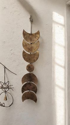 a wind chime hanging from the side of a wall next to other metal items