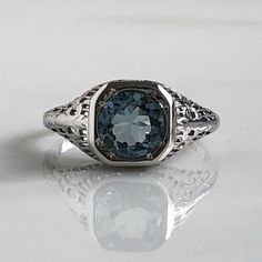 Details: Beautiful Edwardian Aquamarine 18K white gold filigree ring. This ring is very sweet, with delicately detailed filigree with tiny French fleur-de-lis . The aquamarine measures 7.3mm round. The ring is stamped 18K on the inside of the band. Measurements: Ring measures a size 6 1/2 US. It can be re-sized for a fee. Condition: The overall all condition of this ring is very good. Please ask all questions prior to placing an order. Elegant 14k White Gold Signet Ring, Elegant Signet Ring In 14k White Gold, Elegant 14k White Gold Round Signet Ring, Elegant 14k White Gold Signet Promise Ring, Elegant Silver Signet Ring In 14k White Gold, Elegant White Gold Platinum Signet Ring, Elegant Formal Signet Ring With Intaglio, Elegant Intaglio Rings For Formal Occasions, Elegant Formal Intaglio Signet Ring