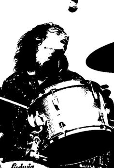 a black and white photo of a man playing drums