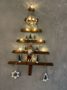 a christmas tree made out of wooden boards with lights on the top and decorations hanging from it