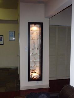 a lighted display case in the corner of a living room