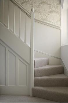 a white staircase with carpeted steps leading up to the second floor