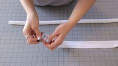 a woman is holding something in her hands while sitting on the floor next to some tape