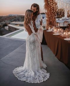 two women standing next to each other in front of a table with candles and lights