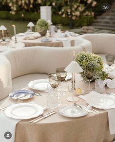 the table is set with white plates and silverware