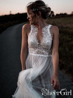 a woman is walking down the road wearing a dress with sheer layers and an open back