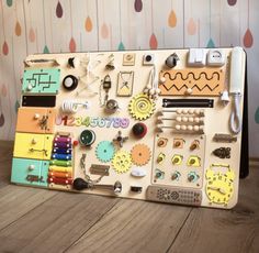 a wooden board covered in lots of different types of buttons and magnets on it