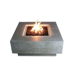 an outdoor fire pit with rocks on the bottom and flames lit up in the middle