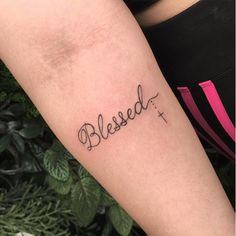 a person with a tattoo on their arm that says, blessed in cursive writing