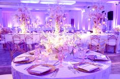 the tables are set with white linens and gold place settings for an elegant wedding reception