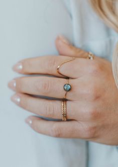 Our Dori ring is made with a gorgeous Labradorite stone. This mystical gemstone is believed to enhance mental clarity and bring about transformation. It's a crystal connected to the third eye chakra which is our gateway to inner wisdom and deeper intuition. 8mm round or 6x8mm oval labradorite stone. Ring band measures 1mm wide. Available in 14kt Gold Fill + Sterling Silver. KJ pairs it with our Sonder Ring, Raye Ring, and Confetti Ring. Handmade in Eau Claire, WI. Our jewelry is handmade so each Copper Uses, Everyday Wear Jewelry, Handmade Jewelry Designs, Labradorite Stone, Wrap Rings, Chain Ring, 14kt Gold, Earring Necklace, Anklets