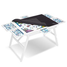 a white table with three pieces of puzzle on it and a black cover over the top