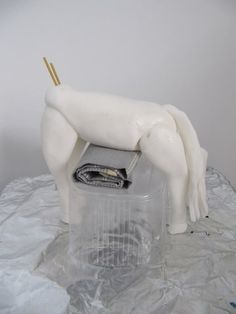 a plastic horse is on top of a plastic container with toothpicks in it