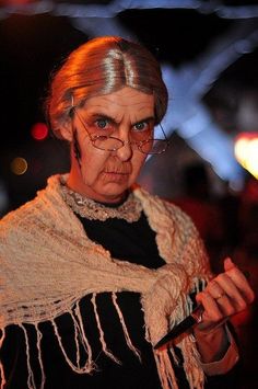 an older woman dressed in costume holding a cell phone