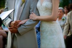 a bride and groom holding hands during their wedding ceremony