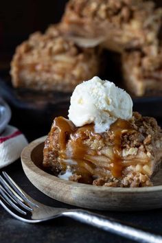 a slice of apple crisp pie on a plate with ice cream and fork next to it