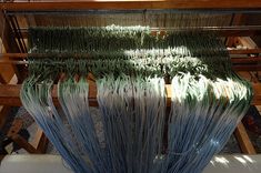 the weaving machine has several rows of blue yarn on it's sides and ends