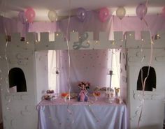 the table is set up with balloons and streamers