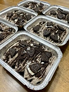 six plastic trays filled with ice cream and oreo cookies on top of a wooden table