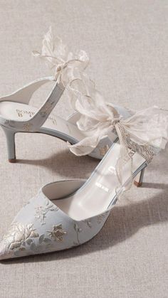 a pair of wedding shoes with bows on the toes and heels are shown in light blue