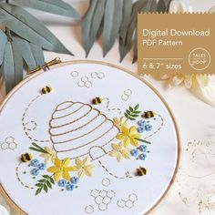 an embroidery pattern with flowers and bees on it