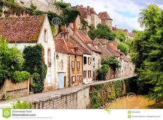 a river runs through the middle of a row of houses in an old european village