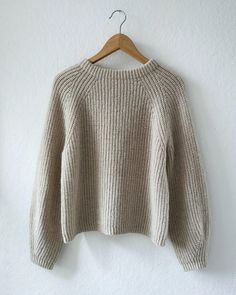 a white sweater hanging on a hanger