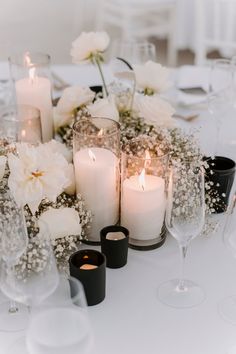 a table topped with lots of white flowers and candles