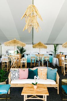 a living room filled with lots of furniture and umbrellas hanging from the ceiling above