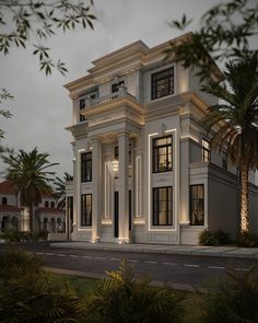 a large white building with lots of windows and palm trees in front of it at night