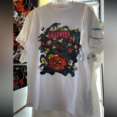 a white t - shirt with the words happy halloween on it hanging in a store