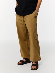 Editor's NotesThese pants from V2 have various styling with drawstrings at the waist and hem.- Banding closure- String at the waist- String at the hem- Wide fit silhouette- Basic and versatile itemMeasurements(in.)M/L- Waist: 12.59 / 13.38 in.- Thigh: 14.96 / 15.55 in.- Hip: 22.83 / 23.62 in.- Front rise: 14.56 / 14.96 in.- Hem: 11.41 / 12.20 in.- Total length: 41.14 / 41.73 in.Model infoMan - Height: 6'06 Fitting size LComposition & Care- 100% Cotton- Please check the care labelDesigner- b Beige Relaxed Fit Pants With Drawstring, Beige Parachute Pants With Hip Pockets For Streetwear, Beige Utility Bottoms With Elastic Waistband, Beige Drawstring Bottoms For Streetwear, Utility Style Khaki Bottoms With Elastic Waistband, Khaki Utility Pants With Elastic Waistband, Utility Style Relaxed Fit Sweatpants With Drawstring, Relaxed Fit Beige Cargo Pants With Drawstring, Beige Relaxed Fit Cargo Pants With Drawstring