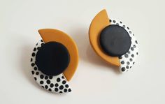 two black, white and yellow earrings with polka dots on the top one is shaped like an earring