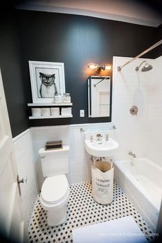 a white toilet sitting next to a bath tub under a bathroom mirror on top of a black and white tiled floor