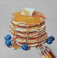 a drawing of a stack of pancakes with blueberries and butter on top, next to colored pencils