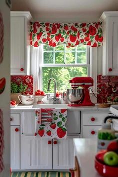 the kitchen is decorated in red and white with apples on the window valances