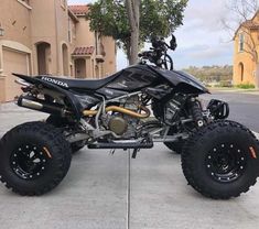 a black and silver four wheeler parked in front of a house