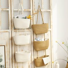 three woven baskets hanging on a wall in front of a white wooden paneled door