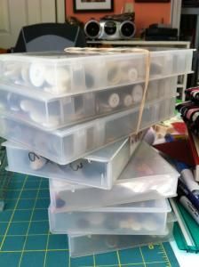 a stack of plastic containers sitting on top of a cutting board next to a pile of scissors