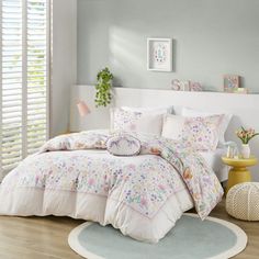 a white bed sitting in a bedroom next to a window