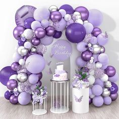 a purple and white birthday party with balloons